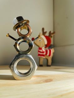 a metal sculpture sitting on top of a wooden table next to a toy horse and reindeer