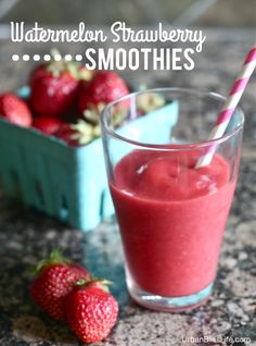 a glass filled with strawberry smoothie next to some strawberries