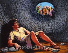 a man laying on the ground in front of a tunnel