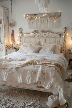 a white bed with lots of pillows and blankets