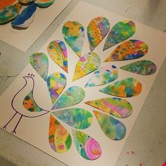 paper cut outs with colorful designs on them sitting on a table next to some scissors