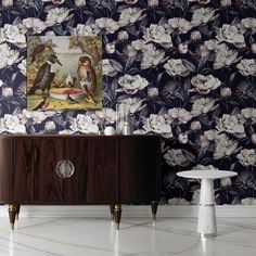 an ornate wallpaper with birds and flowers on it, next to a sideboard