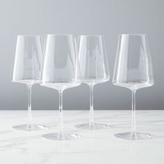 four empty wine glasses lined up on a table