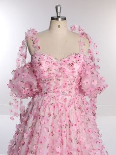 a pink dress on a mannequin with flowers all over the bust and shoulders