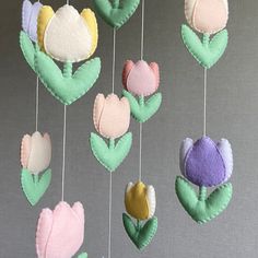 a group of felt flowers hanging from strings