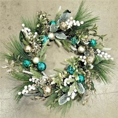 a christmas wreath with ornaments and greenery