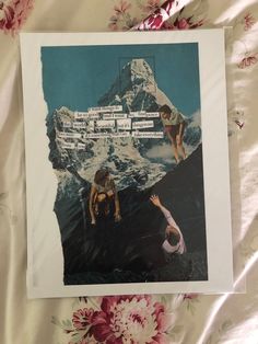 a poster with two people reaching up to the top of a mountain, on a bed