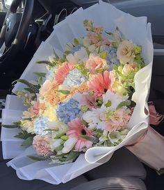 a bouquet of flowers sitting in the passenger seat of a car, ready to be picked up