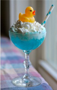 a blue drink with whipped cream and a rubber ducky on top