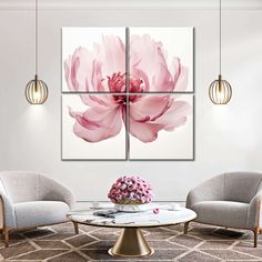 a living room with three chairs and a large pink flower on the wall in front of it