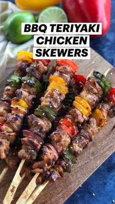 bbq teriyaki chicken skewers on a cutting board with peppers and limes