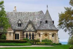 a large house with two towers on top of it's roof and green grass in front of it