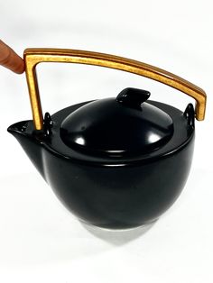 a black tea pot with a wooden handle