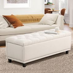 a white couch sitting on top of a carpeted floor next to a wooden table