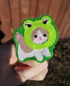 a person holding up a small felt animal