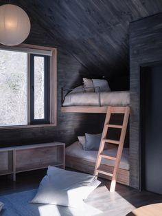 a bunk bed in the corner of a room next to a window with a ladder