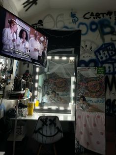 a room with two tvs and graffiti on the walls, one has a man in a white lab coat