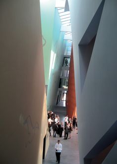 a man walking down a hallway between two tall buildings