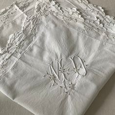 four white linens with embroidered designs on them