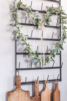 a heart shaped wreath hanging on a wall next to cutting boards