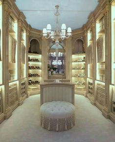 an elegant walk - in closet with chandelier and shoe storage area for shoes