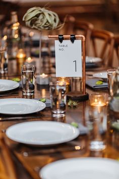 the table is set with plates and place cards for guests to sit down at it