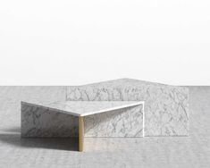 a white marble coffee table sitting on top of a gray floor next to a wall