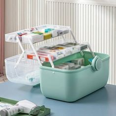 a blue table topped with two containers filled with supplies