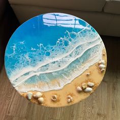 a cake decorated with seashells and sand on a wooden table next to a couch