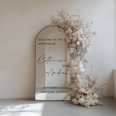 a welcome sign next to a bouquet of flowers in front of a mirror with the words, welcome to the wedding of california and arizona