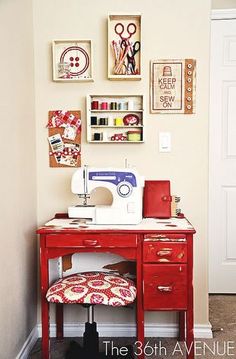 a sewing machine sitting on top of a wooden desk next to a red table and chair