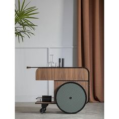 a wooden table with speakers on it next to a potted plant