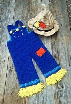 two crocheted items laying on top of a wooden floor next to a straw hat