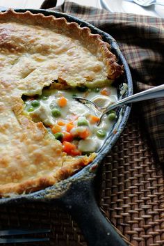 a close up of a pie in a pan on a table with a fork sticking out of it