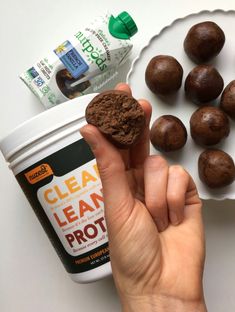 a person holding a cookie in their hand next to some chocolate truffles