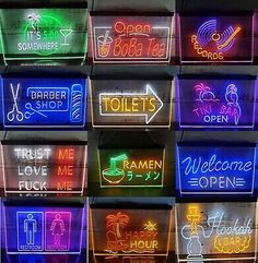 neon signs are displayed on the side of a building