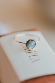 Our Dori ring is made with a gorgeous Labradorite stone. This mystical gemstone is believed to enhance mental clarity and bring about transformation. It's a crystal connected to the third eye chakra which is our gateway to inner wisdom and deeper intuition. 8mm round or 6x8mm oval labradorite stone. Ring band measures 1mm wide. Available in 14kt Gold Fill + Sterling Silver. Juliann stacks it with our Swell Ring and 2 Confetti Rings. KJ pairs it with our Sonder Ring, Raye Ring, and Confetti Ring. Minimalist 14k Gold Jewelry With Cabochon, Yellow Gold Labradorite Ring For Gift, Gift Moonstone Ring In 14k Gold With Oval Cabochon, 14k Gold Moonstone Ring Oval Cabochon For Gift, Opal Halo Jewelry As Gift, Gift 14k Gold Moonstone Ring Oval Cabochon, 14k Gold Moonstone Ring Gift, Oval Cabochon, Minimalist Oval Cabochon Wedding Jewelry, Minimalist Oval Cabochon Jewelry