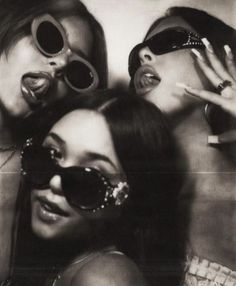 three women with sunglasses on their heads posing for the camera