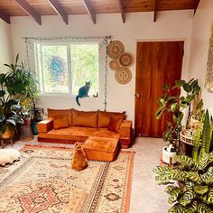 a living room filled with lots of furniture next to a large rug and potted plants