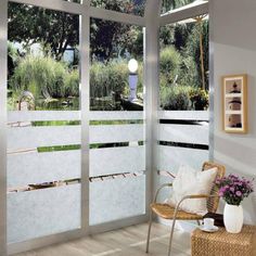 a chair sitting in front of a sliding glass door that opens to a garden area