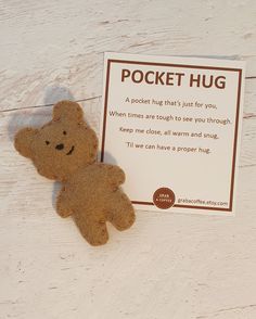 a teddy bear sitting next to a pocket hug card