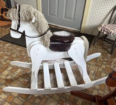 a white rocking horse sitting in front of a door