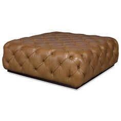 a brown leather ottoman sitting on top of a white floor