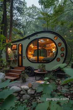 a tiny house in the woods with stairs leading up to it's door and windows