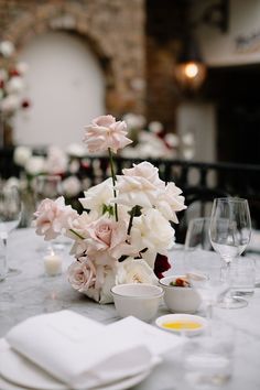 the table is set with white and pink flowers