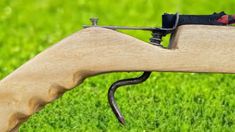 a close up of a wooden object with scissors on it's end and grass in the background