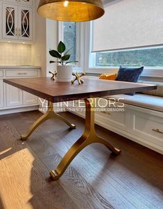 a kitchen with white cabinets and wood flooring next to a large window sill