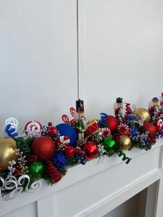 christmas decorations are lined up on the mantle in front of a white fireplace mantel