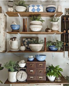 a shelf filled with lots of different types of pots and bowls on top of wooden shelves