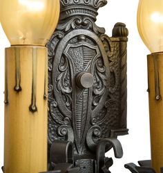 an ornately designed wall light with two lamps on each side and a wooden pole in the middle